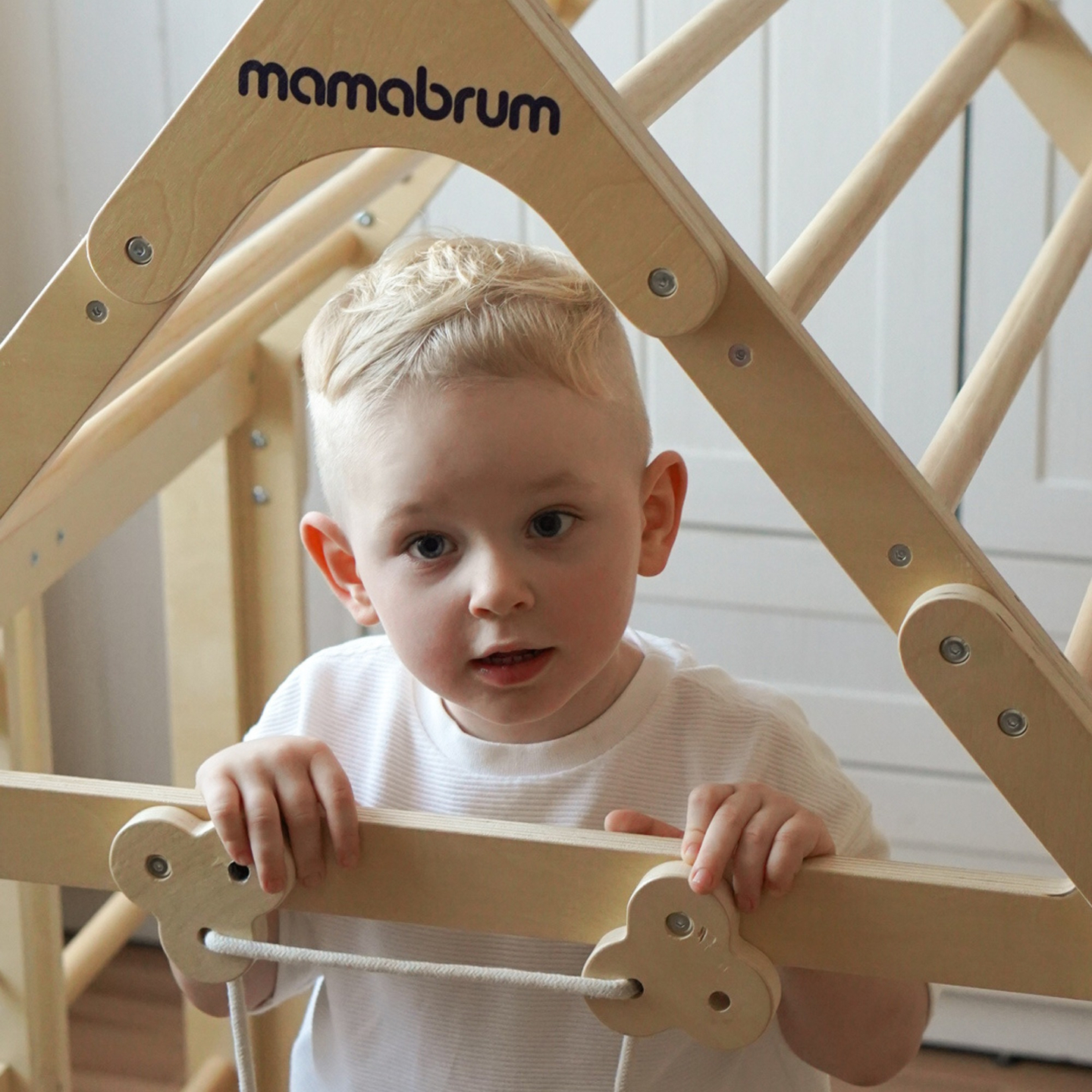 Parque infantil interior de madera: una casa con escaleras y tobogán.