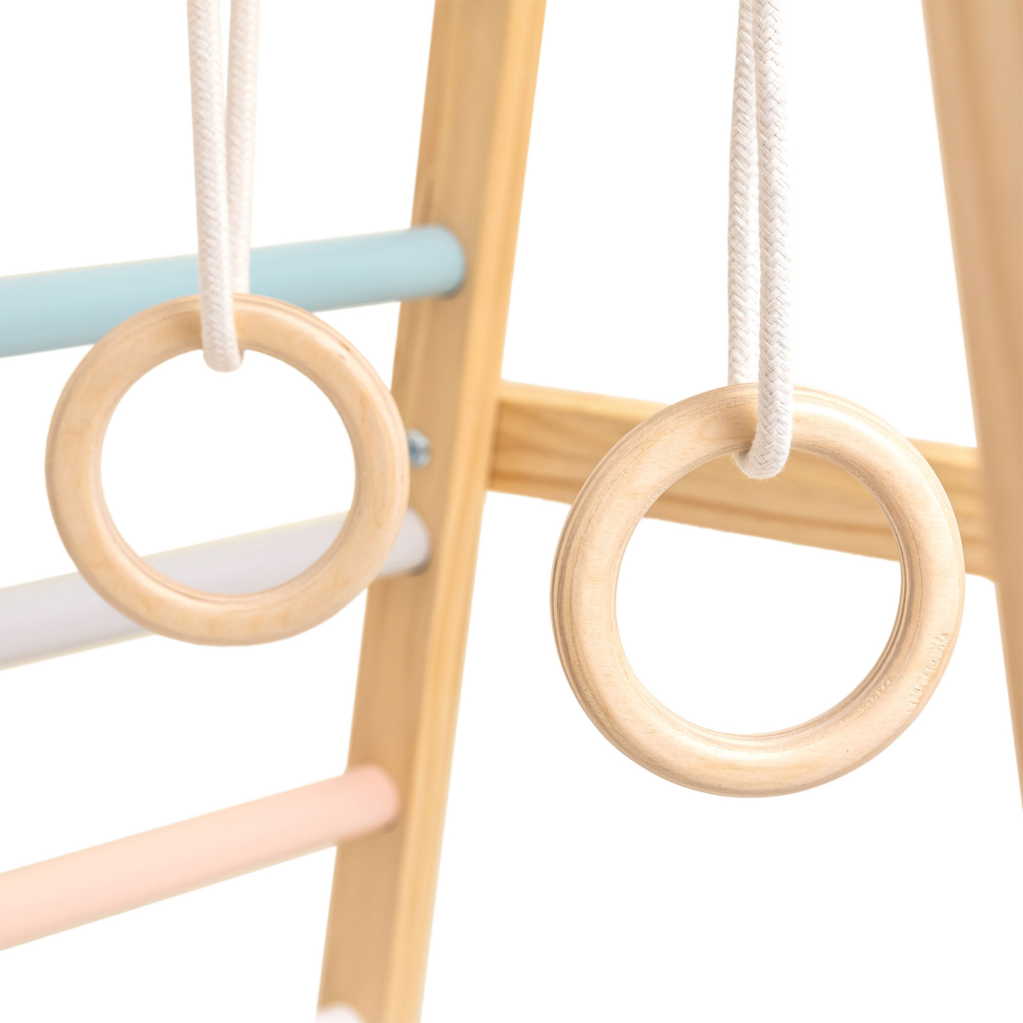 Parque infantil interior de madera con columpio, anillos de gimnasia y red de escalada.