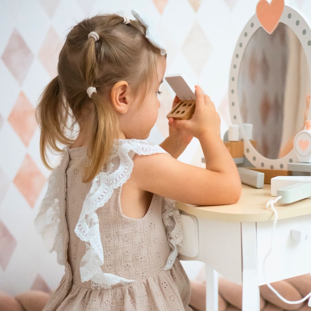 Tocador de madera con taburete y accesorios.