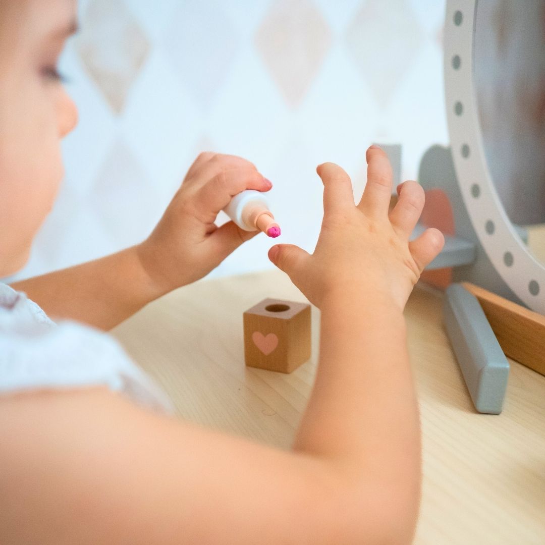 Tocador de madera con taburete y accesorios.