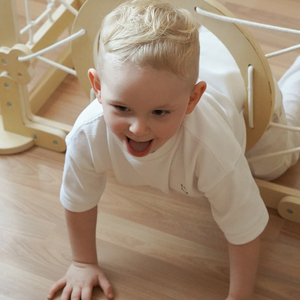 Parque infantil interior de madera: una casa con escaleras y tobogán.